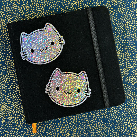 Two of the vinyl stickers decorating a small sketchbook