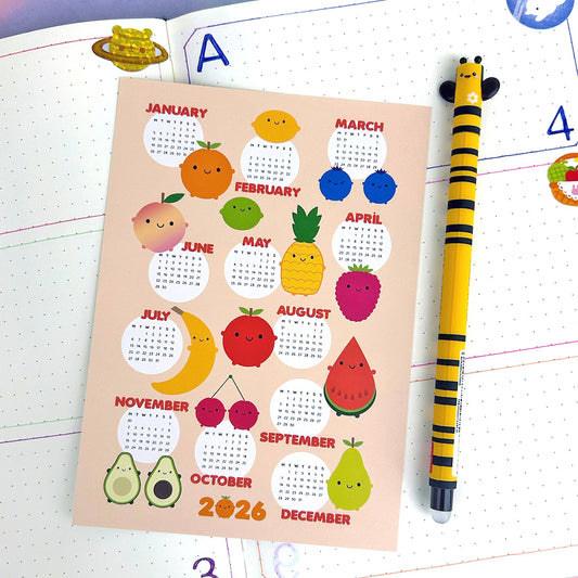 Calendar with fruit-themed design for 2026 on a journal with a pen.