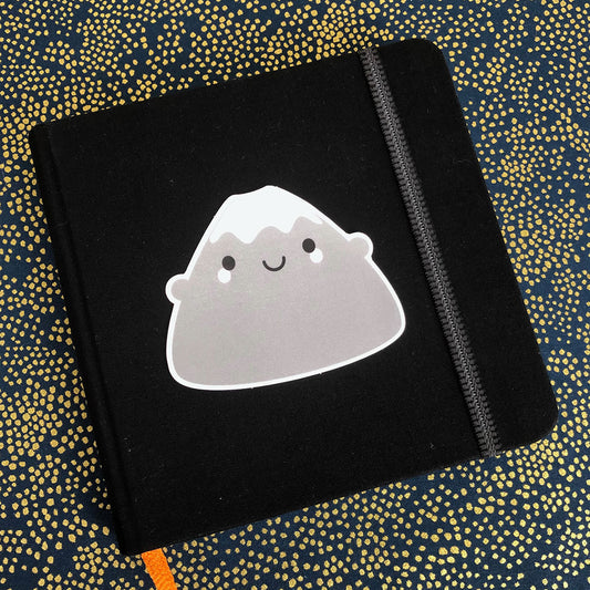 A Mt Fuji vinyl sticker displayed on a small sketchbook
