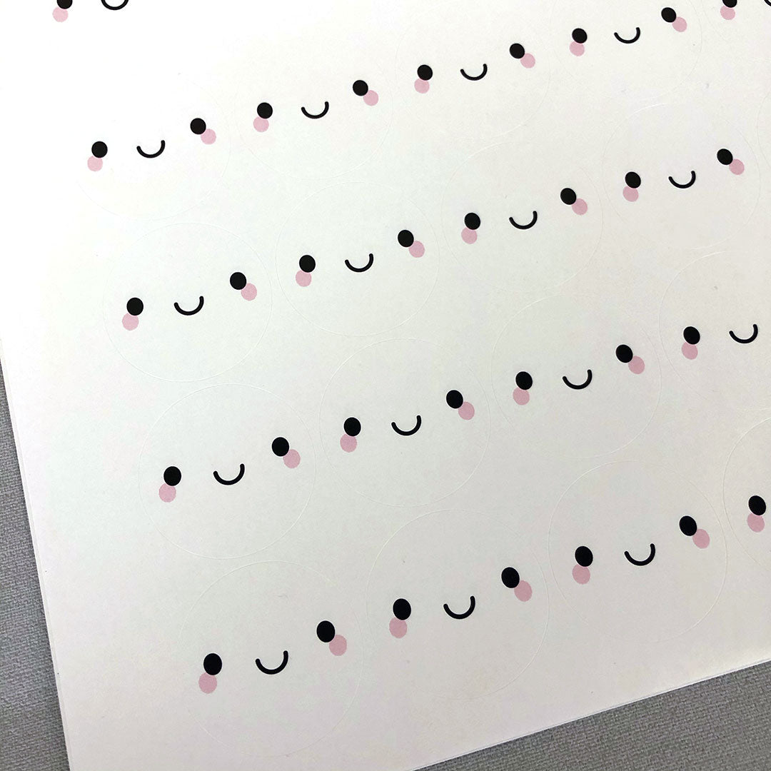 Close up of stickers - each has a kawaii face on a white background