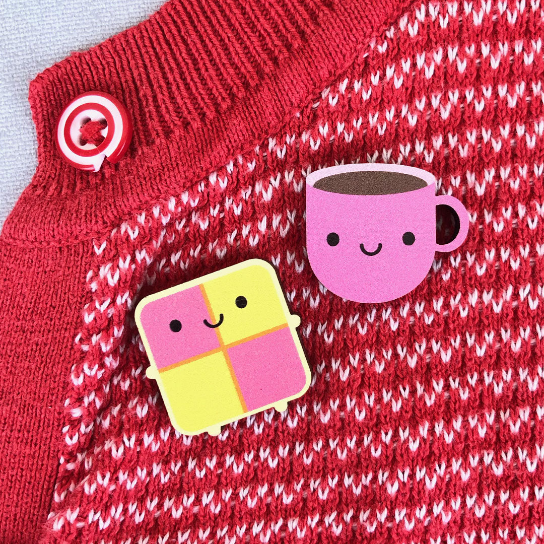 Pink Cup & Battenberg Cake pinned to a red cardigan