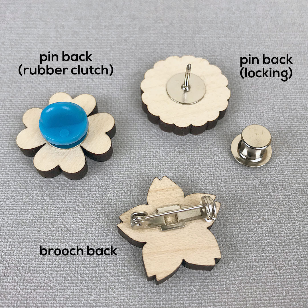 Examples of a brooch back, pin back, rubber clutch and locking back