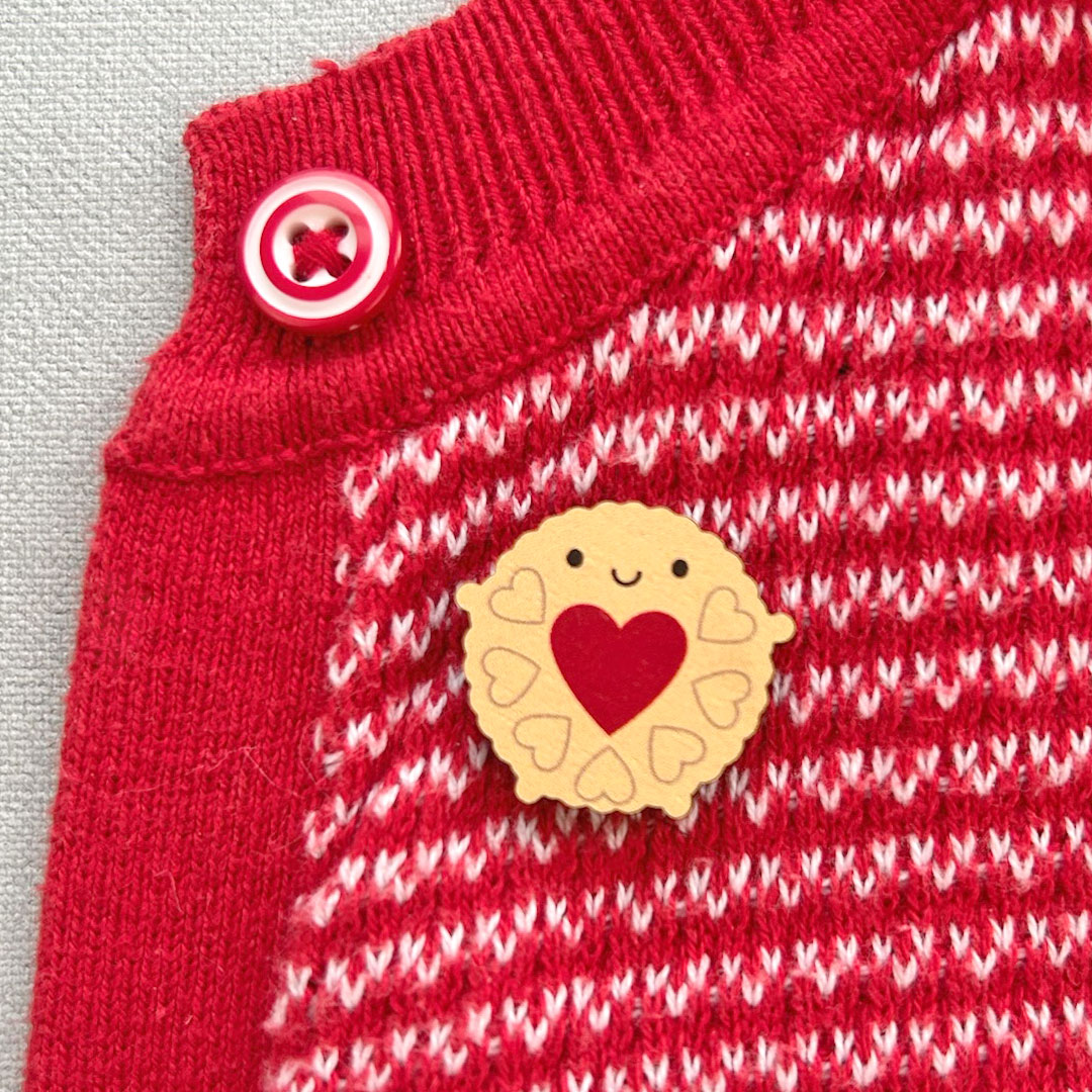 Jammie Dodger pinned to a red cardigan