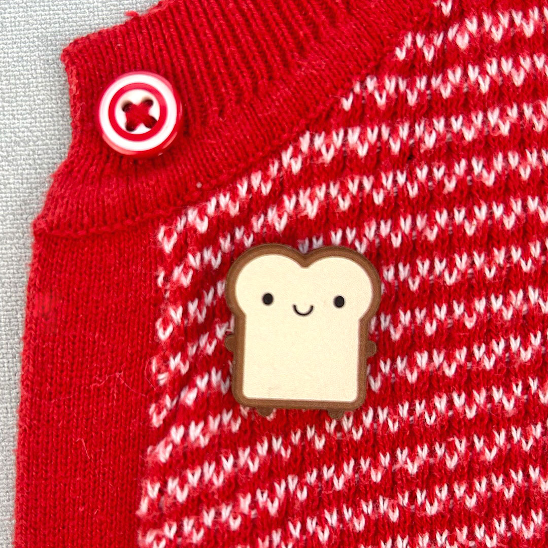 Toast pinned to a red cardigan