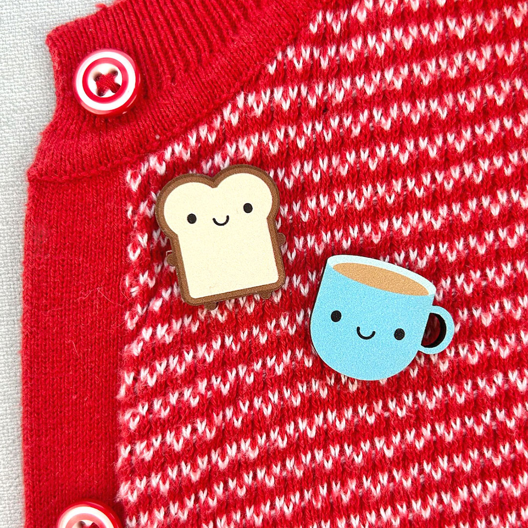 Toast & Blue Cup pinned to a red cardigan