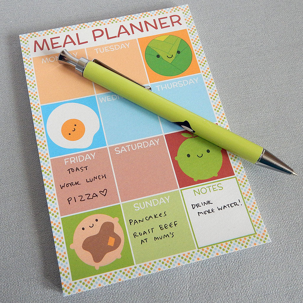 Example of meal planner notepad in use with hand-written notes and pen for scale
