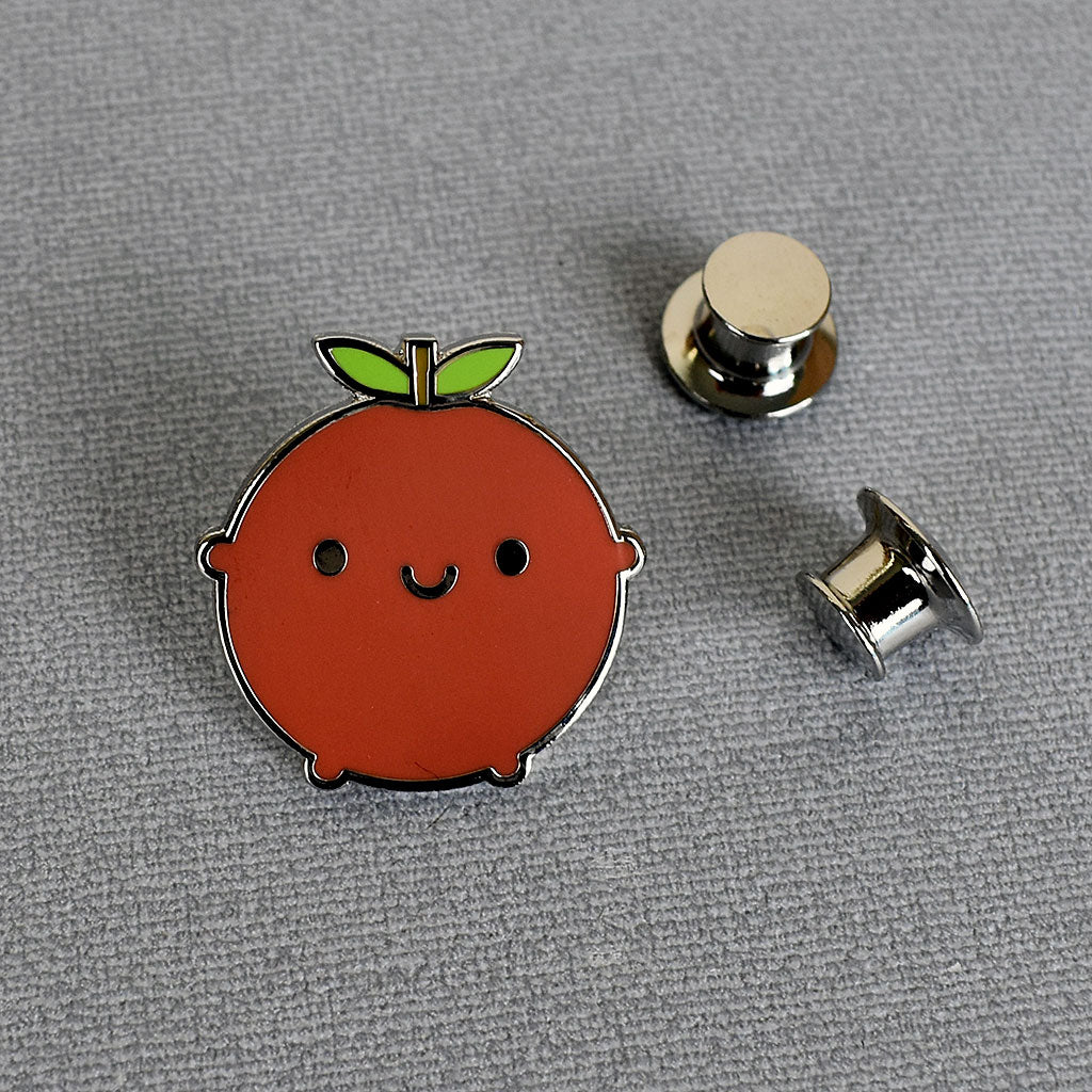 A Happy Apple enamel pin with 2 locking backs