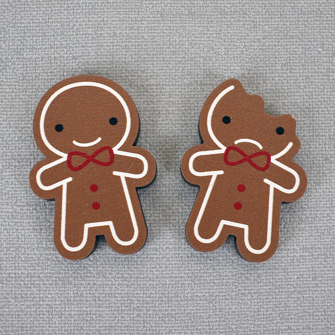 The 2 kawaii Gingerbread Man brooches on a grey background