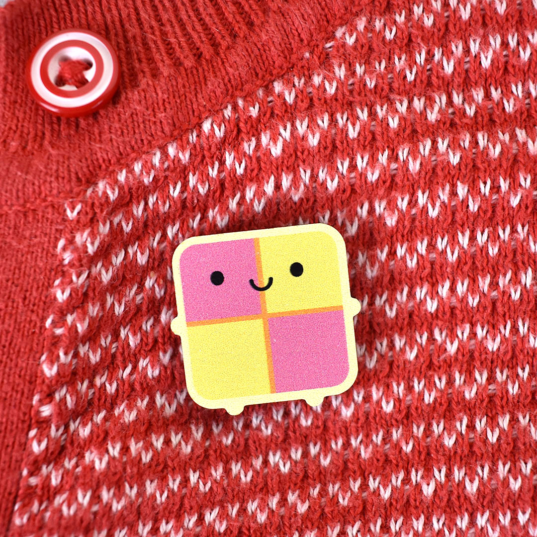 A happy kawaii Battenberg Cake brooch made from ethically sourced, FSC certified wood
