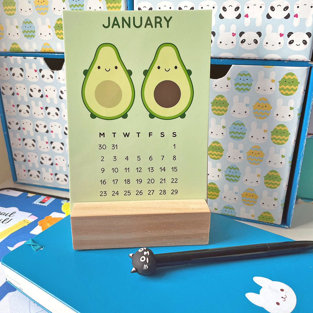 The postcard set displayed in a wooden block holder on a desk showing the January design