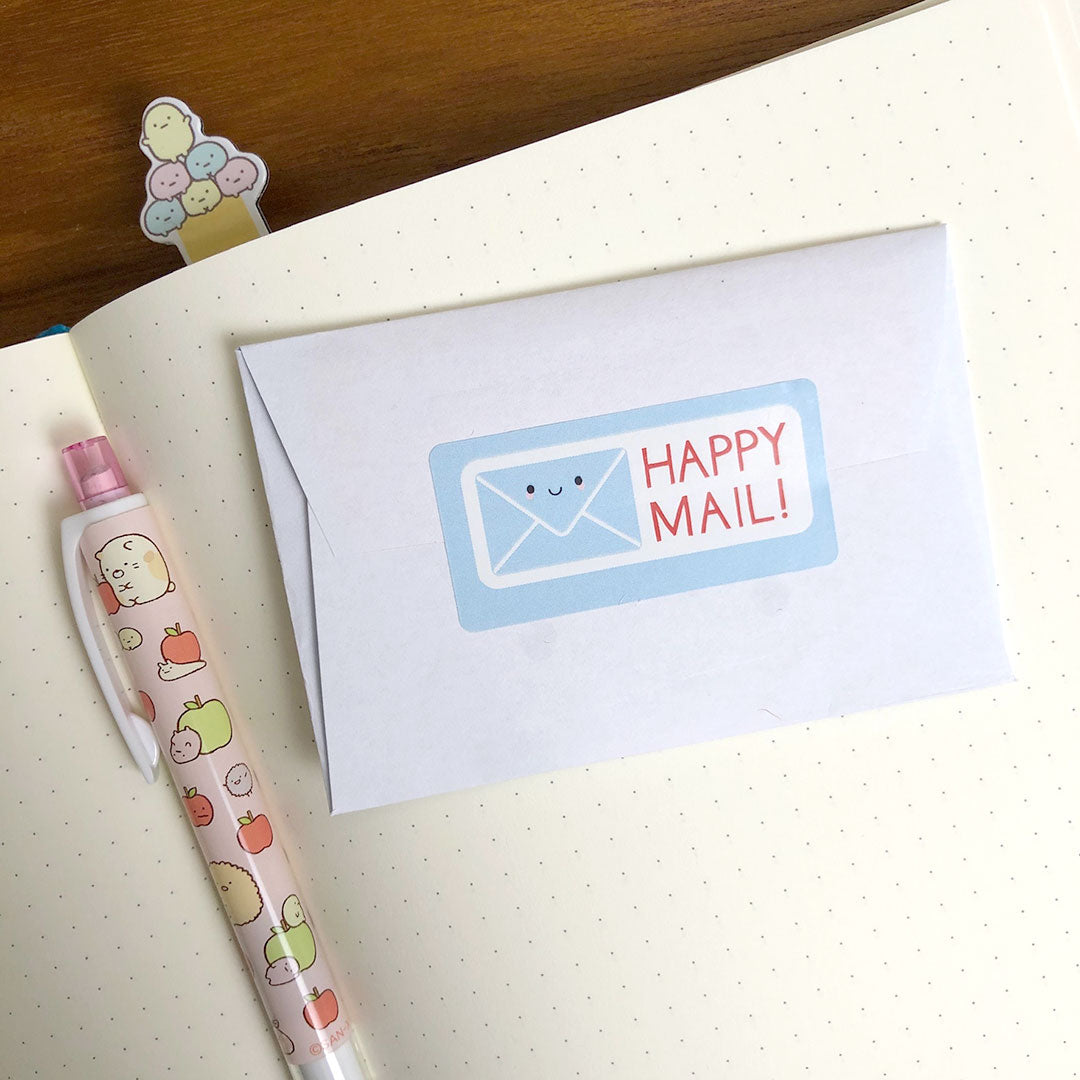 A happy mail sticker used as a seal on a small envelope