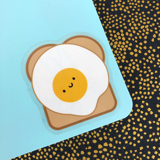 A die cut vinyl sticker of a happy Fried Egg on Toast with a clear border