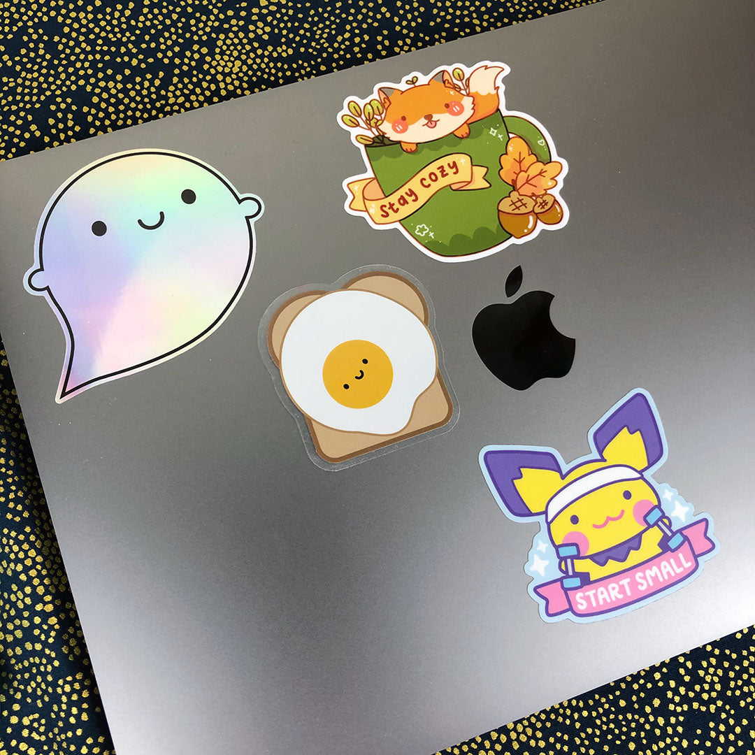 A laptop decorated with various cute stickers including the Egg on Toast