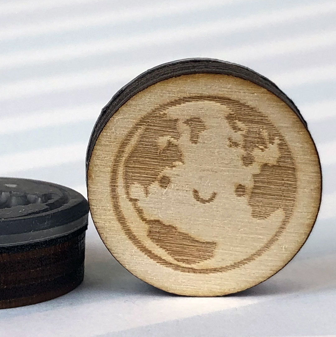 Close up of 2 Earth stamps showing the laser engraving and height