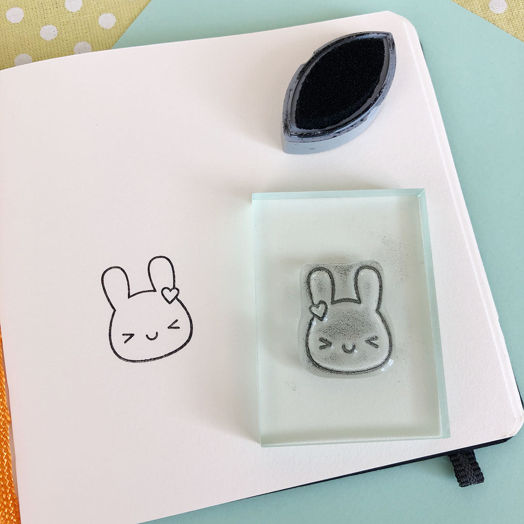 The inked up Bunny stamp on a block and the stamped design on a notebook page