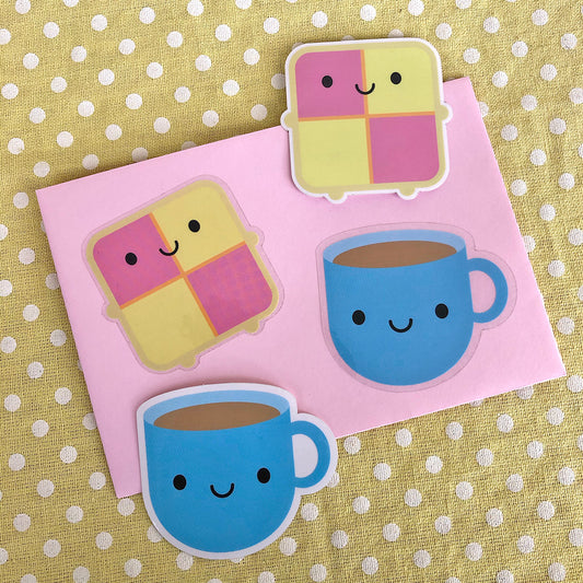 Four die cut vinyl stickers of happy blue tea cups and battenberg cakes, some showing the clear border