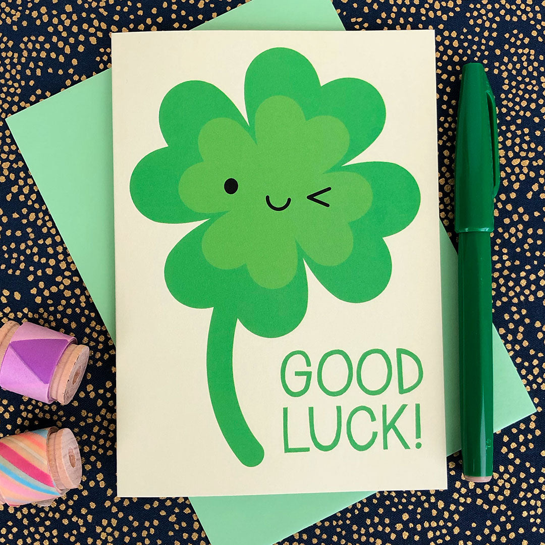An illustrated card with a happy winking four leaf clover and the words Good Luck!