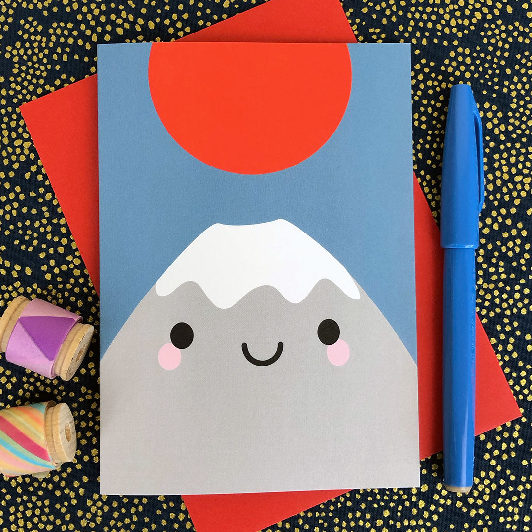 An illustrated card with happy Mt Fuji and red sun