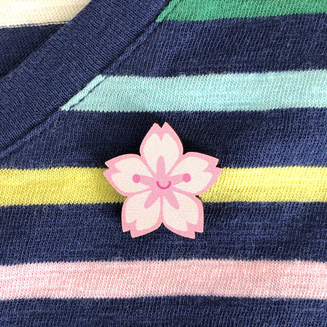 A happy kawaii Sakura cherry blossom brooch made from ethically sourced, FSC certified wood