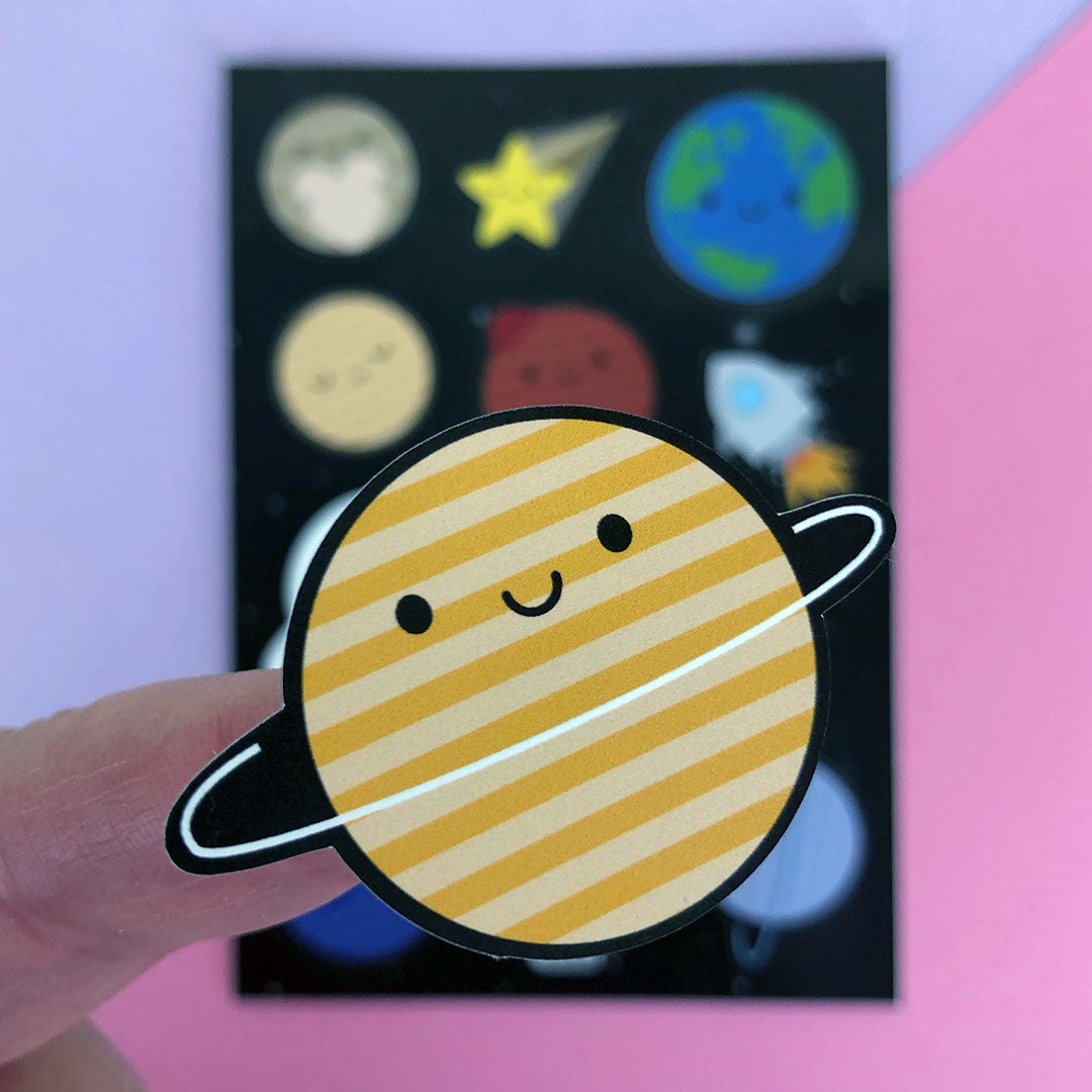 A close up of a die cut Saturn sticker