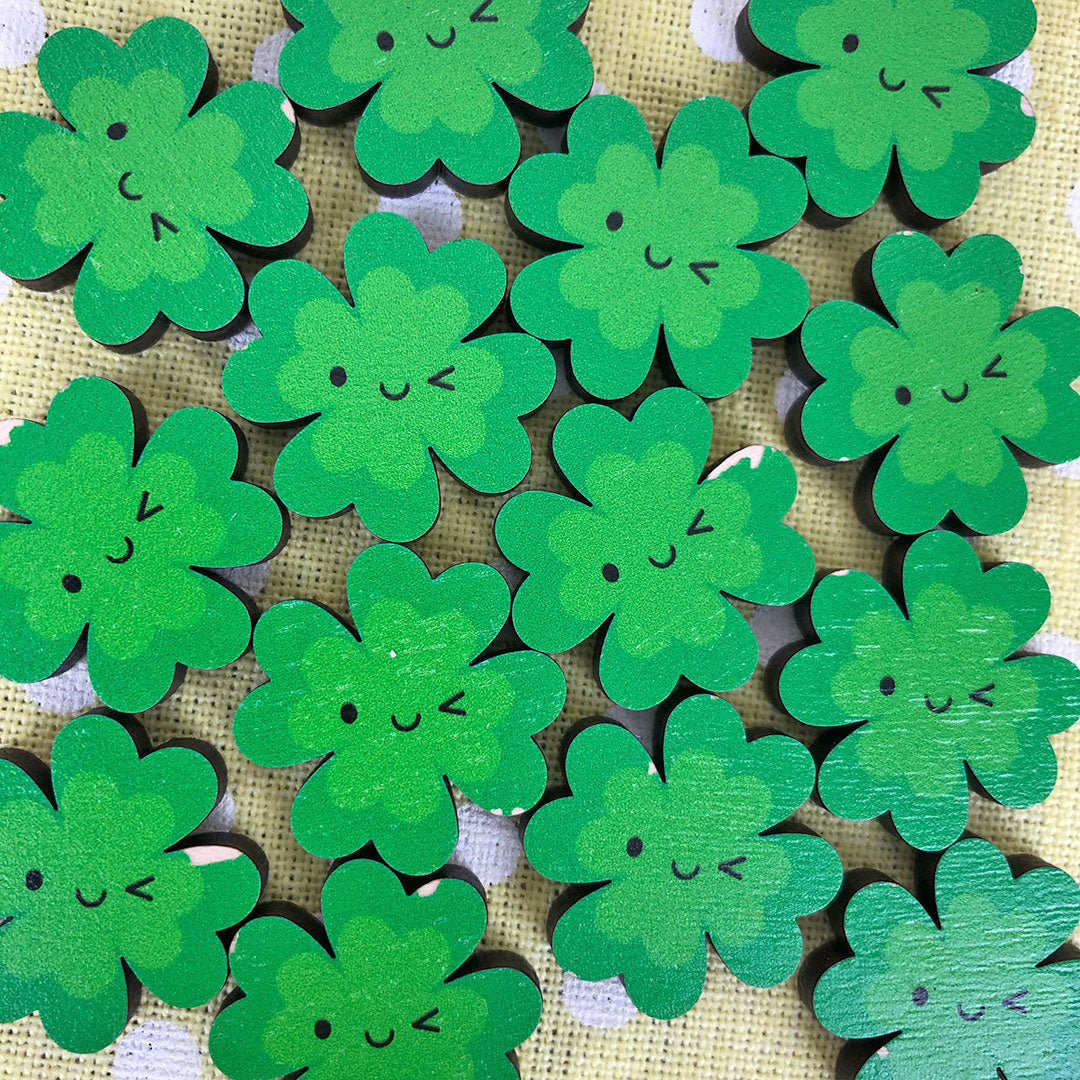 Damaged Lucky Clover wooden brooches with small parts of the design missing around the edges