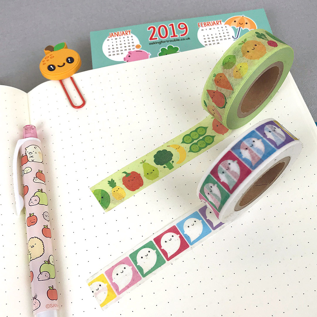 Rolls of Rainbow Ghosts and 5 A Day washi tape on a journal