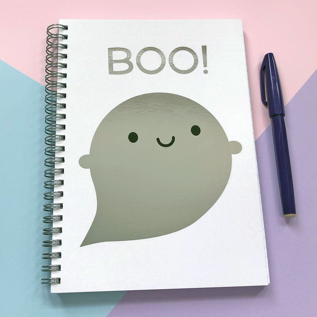 Spiral bound notebook with a happy kawaii ghost and the word BOO!, both in silver mirror foil