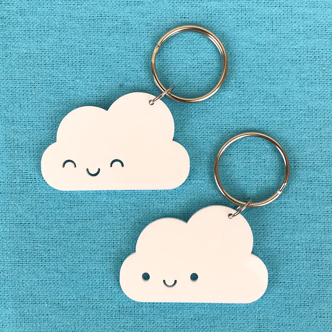 Happy Cloud keyrings with open and closed eyes laser cut from white acrylic, each with a split ring attached