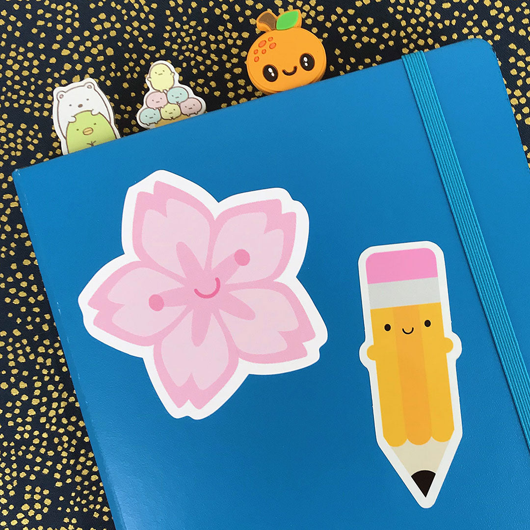 A notebook decorated with stickers including the Pencil