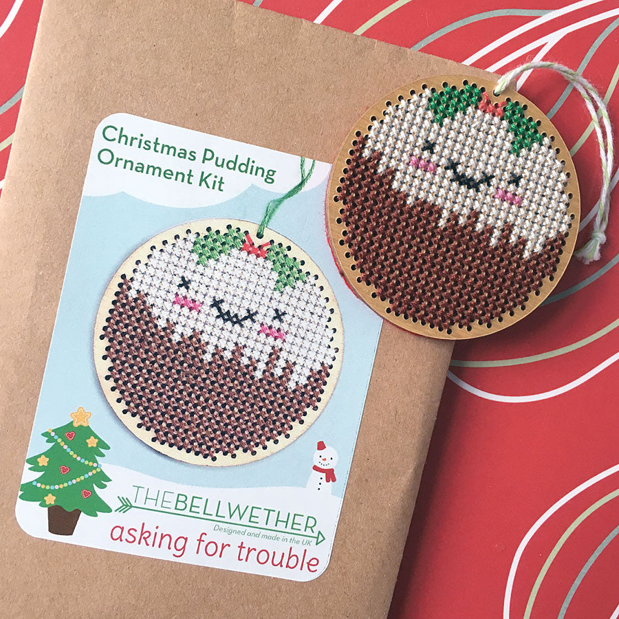 A finished Christmas Pudding cross stitch ornament with a packaged kit
