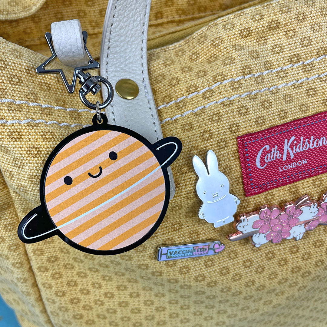 The keyring used as a bag charm on a yellow handbag