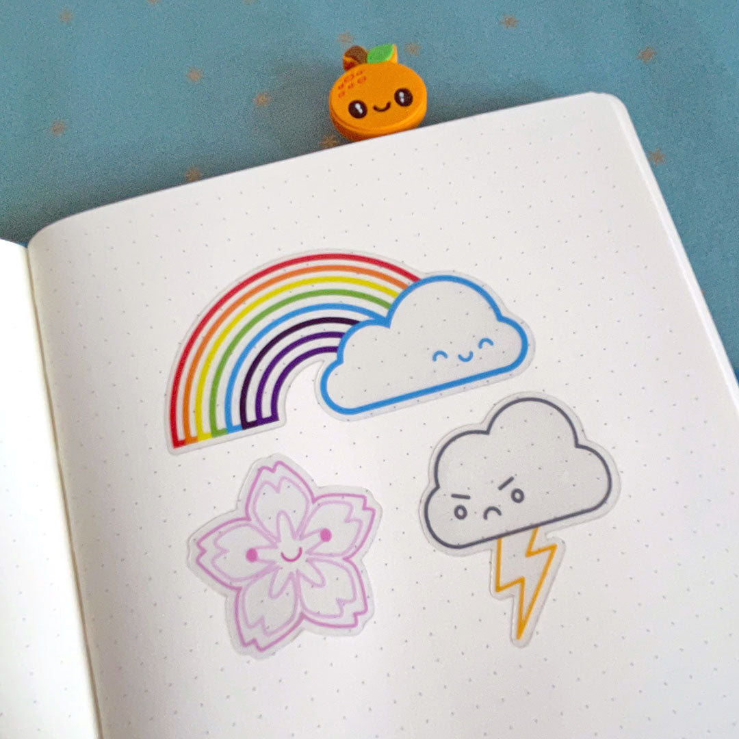 The clear Rainbow, Sakura & Thunder Cloud stickers on a notebook page