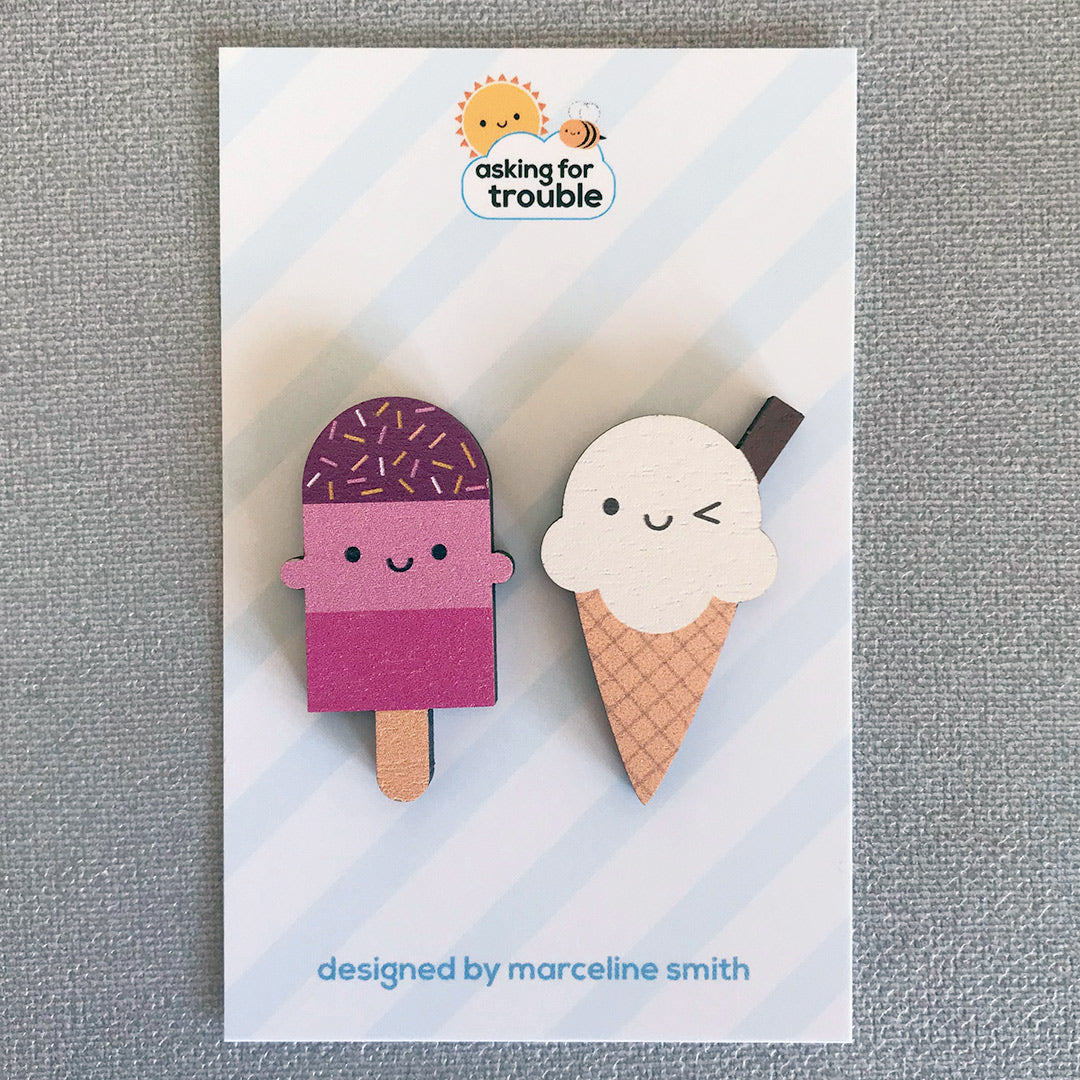 Brooches/pins are packaged on an illustrated backing card