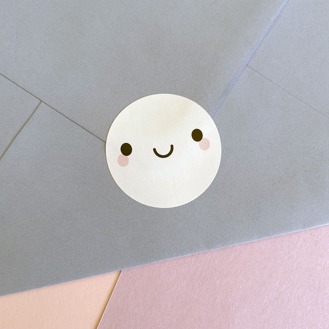 Close up of a Smiley Face sticker sealing a blue envelope