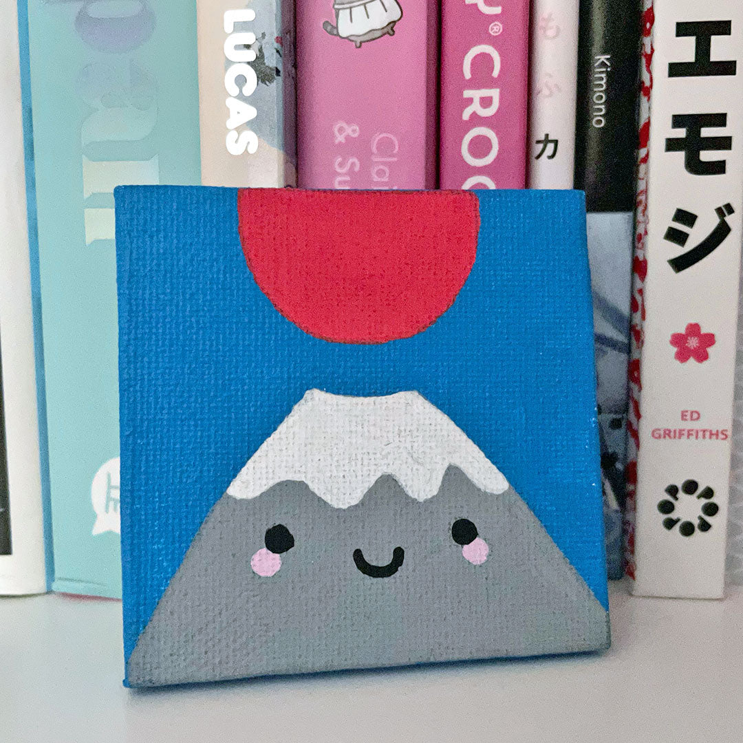 Mt Fuji painting displayed on a shelf of Japan books