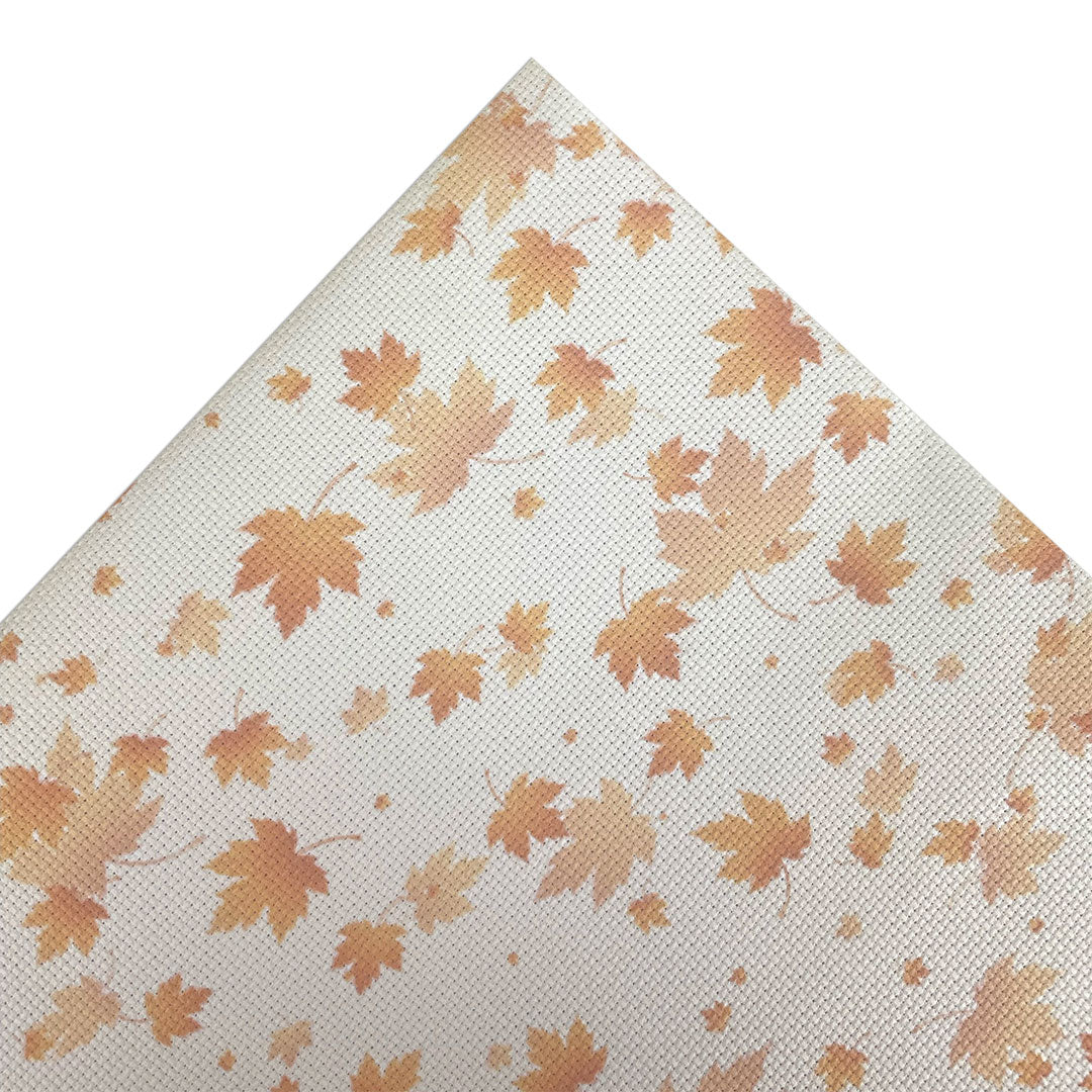 Aida fabric digitally printed with orange/brown leaves on a white background
