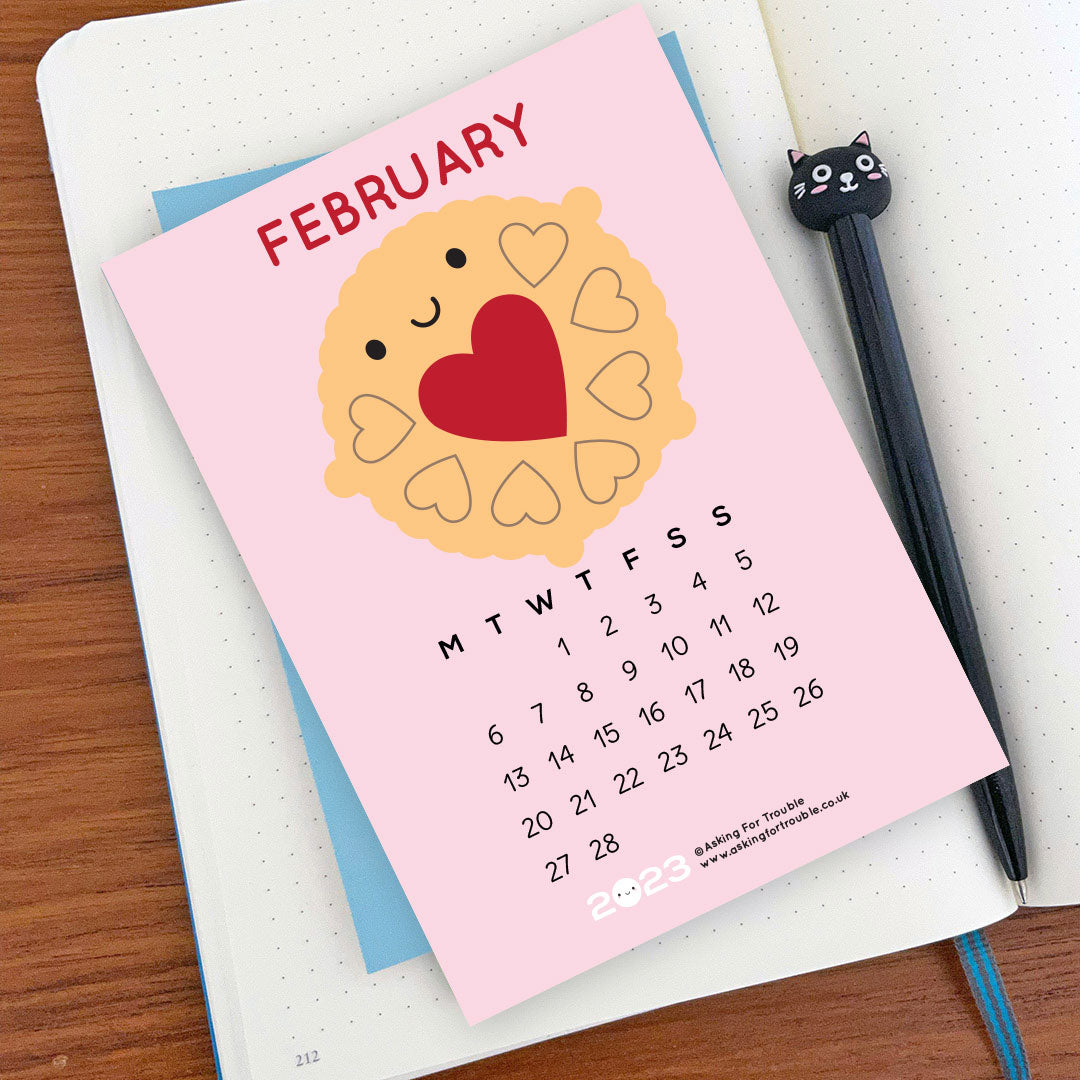 The February postcard with Jammie Dodger on a notebook with pen