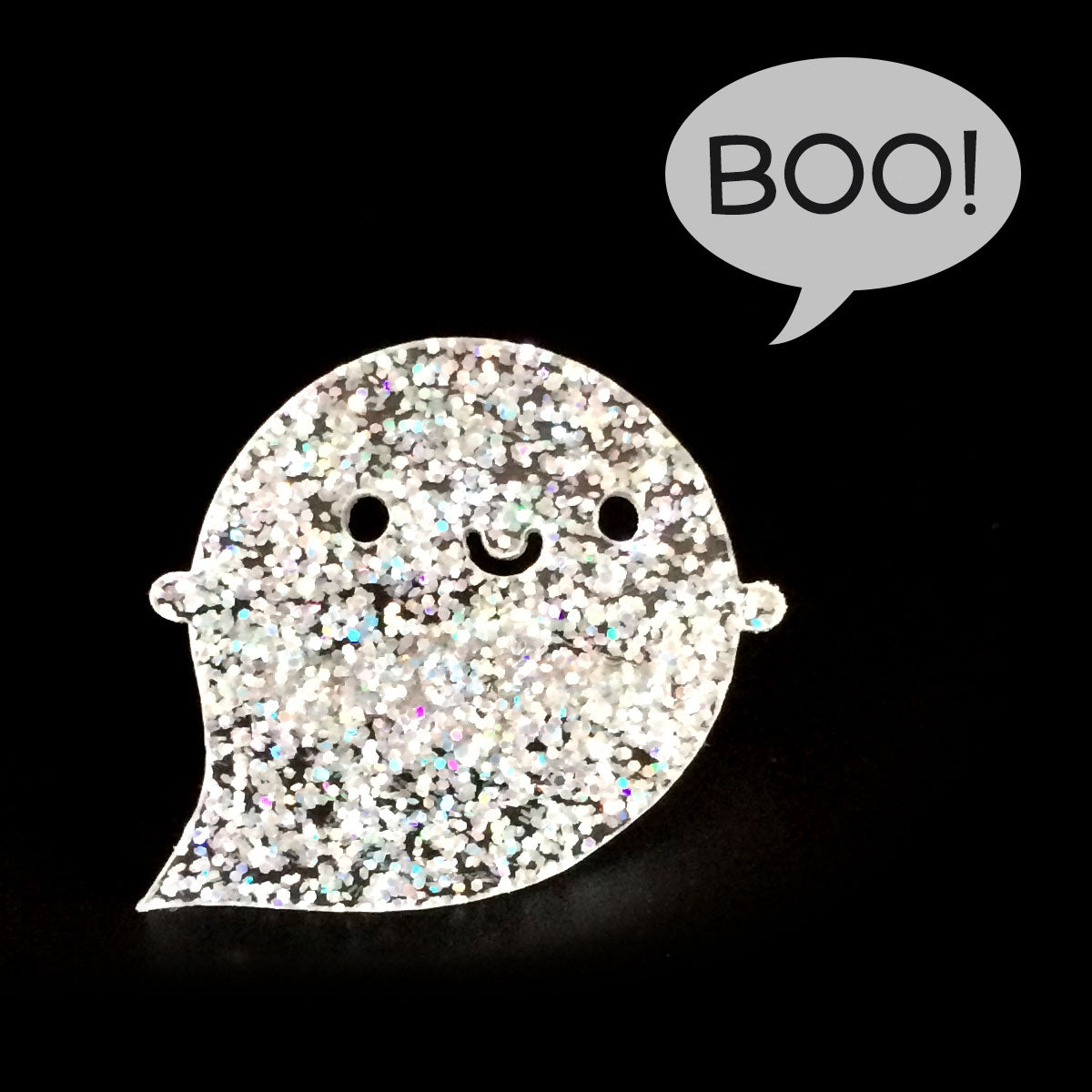 A happy kawaii ghost brooch made from holographic glitter acrylic with a BOO! speech bubble