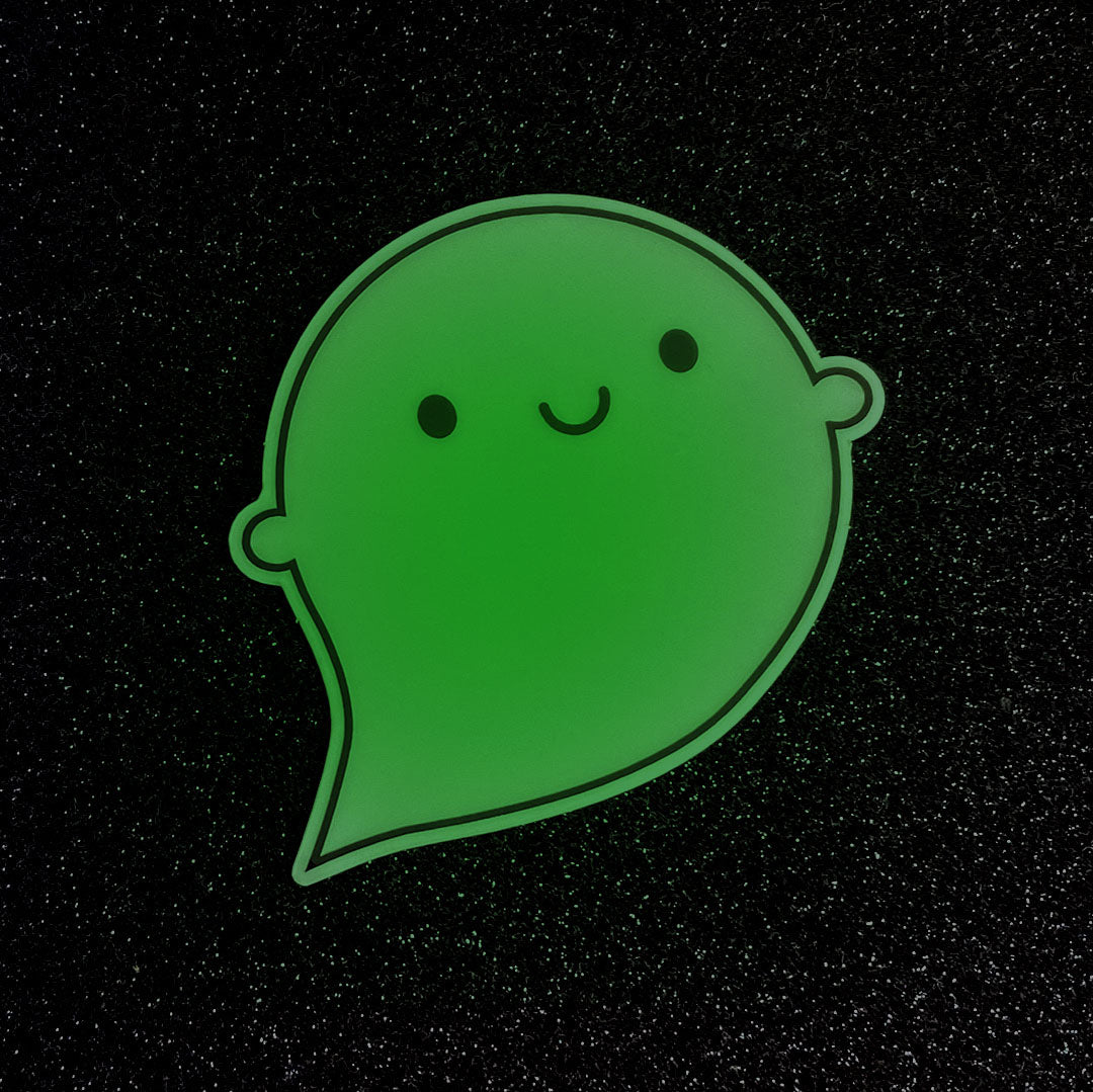 A die cut vinyl sticker of a happy ghost showing the green glow
